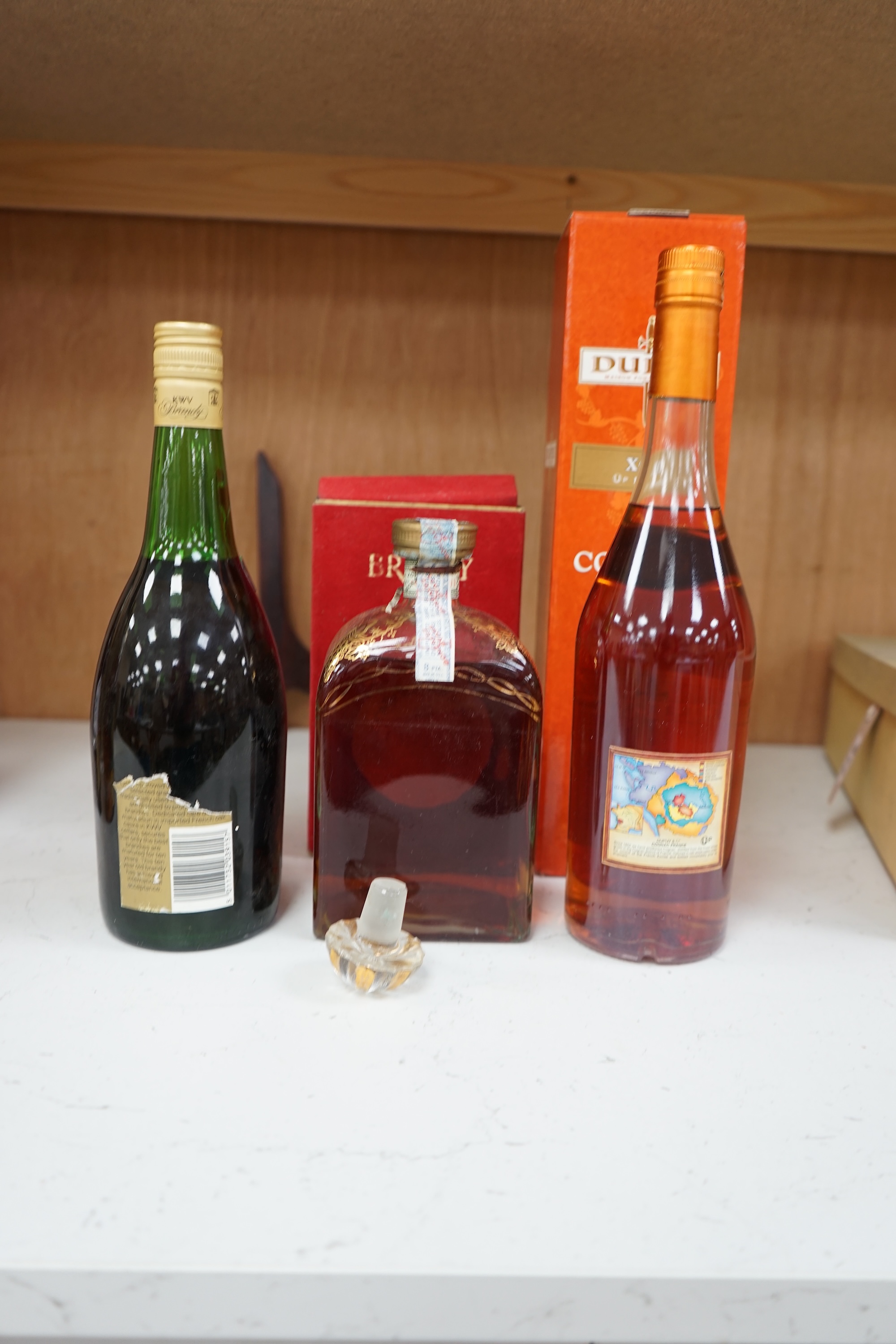 Three bottles of brandy comprising KWV Ten Year brandy, Dupuy cognac and Lepanto brandy. Condition - fair, storage history unknown